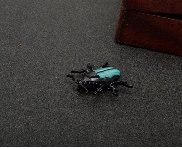 broche en forme de scarabée noir et vert