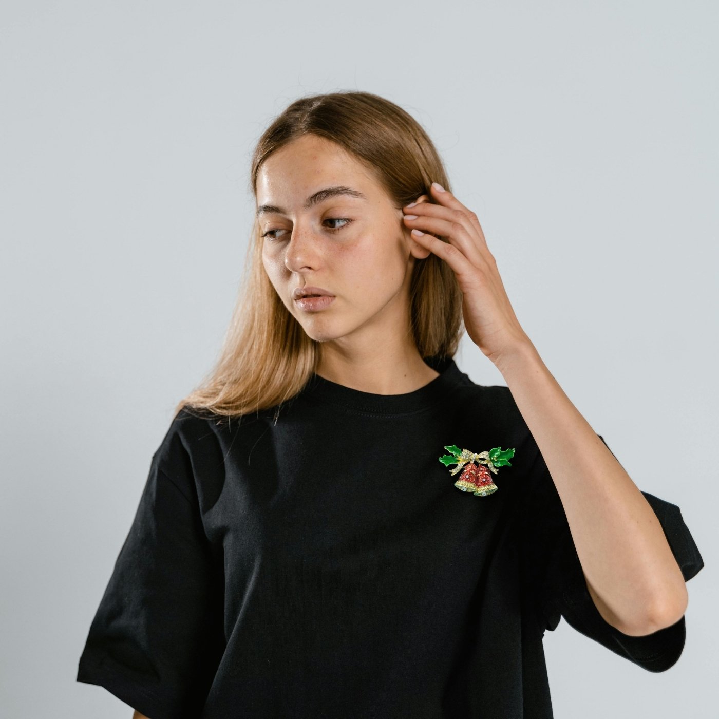 Broche festive avec deux cloches de Noël décorées et nœud scintillant en strass