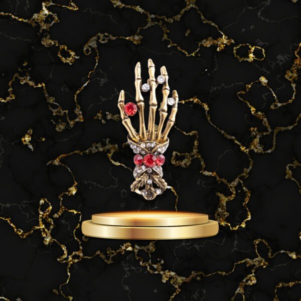 Broche fantaisie main squelette décorée de pierres