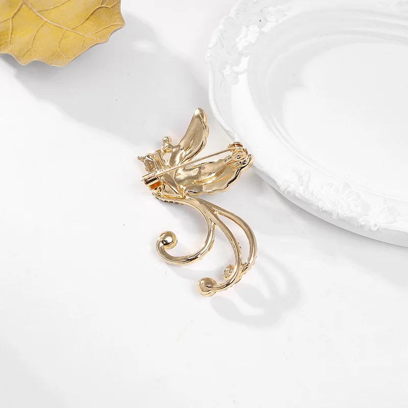 Broche Mims en forme de phoenix sur un vêtement