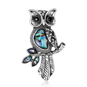 Broche hibou pétale bleu sur un fond neutre