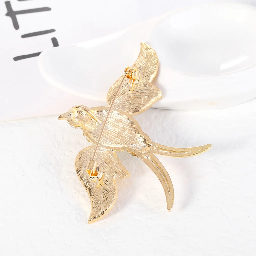 Détail de la broche Oiseau Œil Rouge montrant son design unique